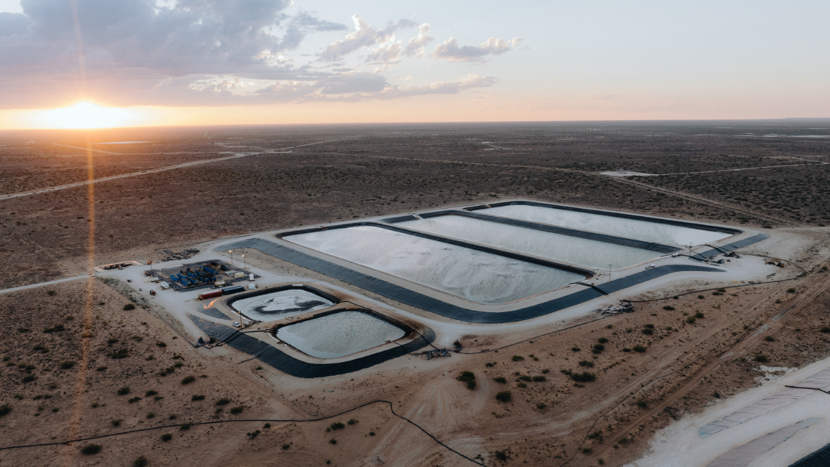 Aerial view of large shale water ponds in a desert basin at sunrise.