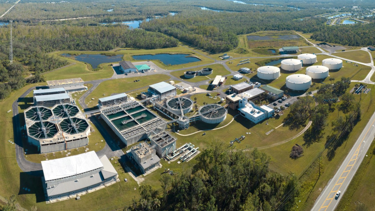 Water treatment plant with circular clarifiers, storage tanks and surrounding wetlands