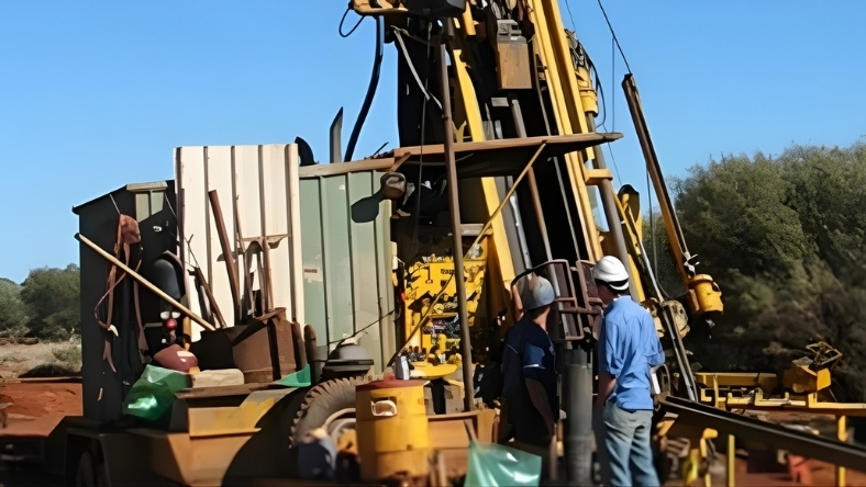 Workers operate a drilling and disposal rig at an onshore shale site