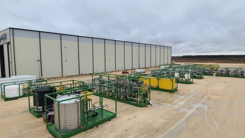 Modular industrial processing units beside large storage tanks